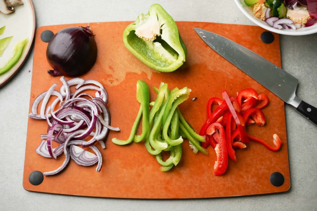 sliced red onion and bell peppers