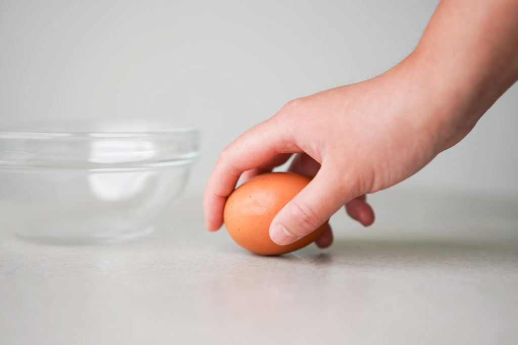 cracking an egg on a flat surface