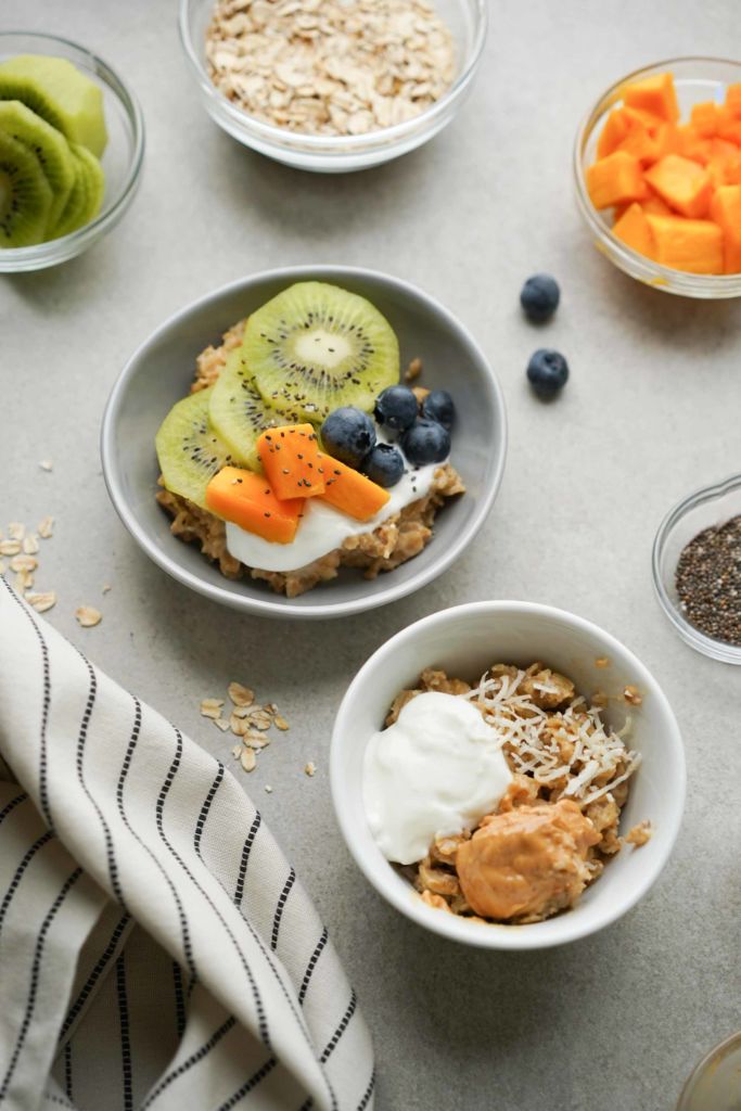 two oatmeal bowls with fruit and yogurt