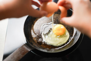 cracking egg into frying pan
