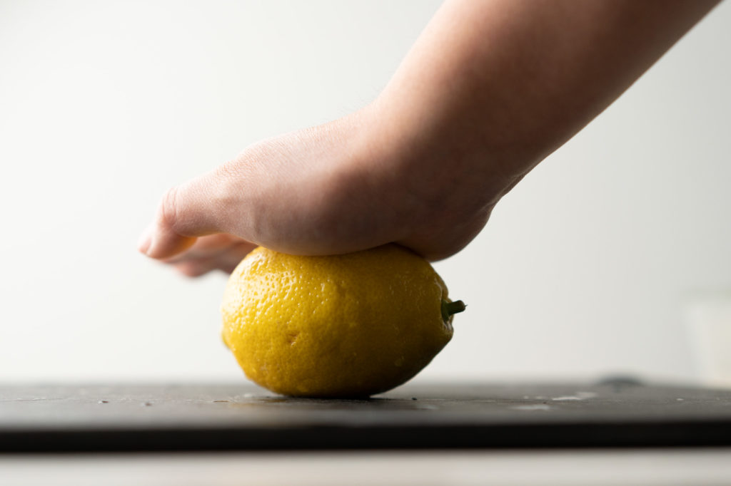 rolling lemon on cutting board