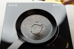 pouring oil onto pan