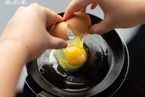 cracking egg onto carbon steel pan