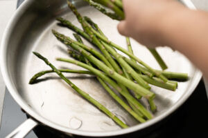 adding asparagus to pan