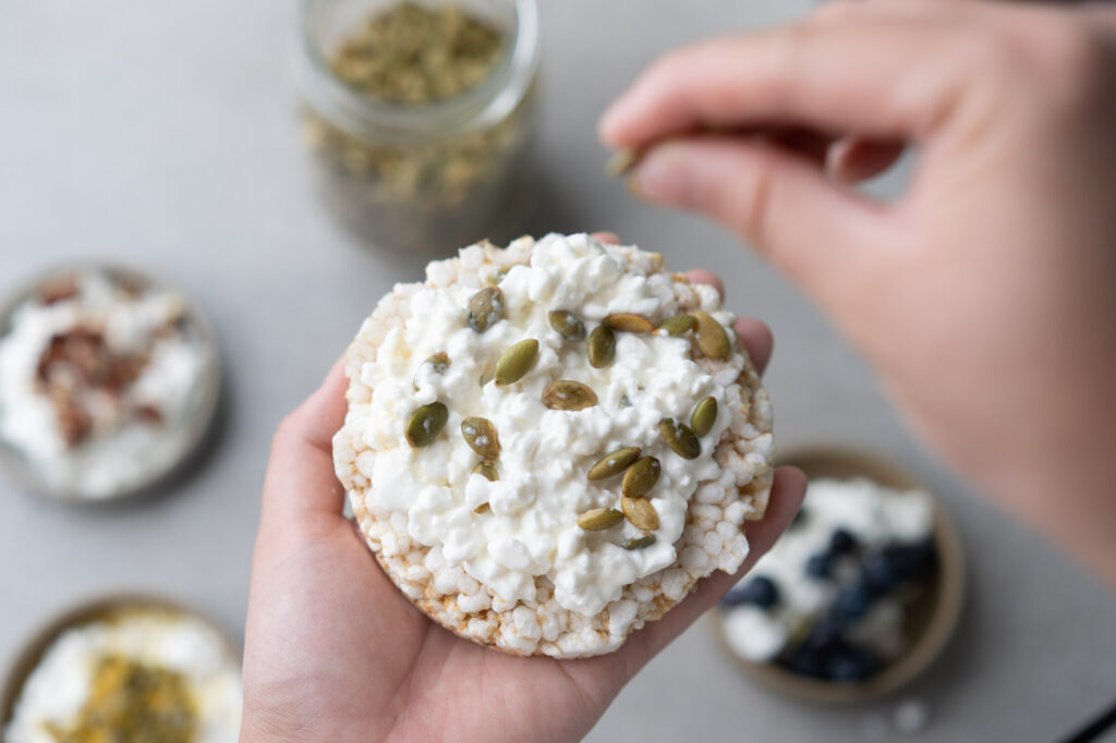 cottage cheese on a rice cracker with pumpkin seeds
