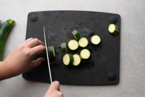 slicing zucchini on cutting board