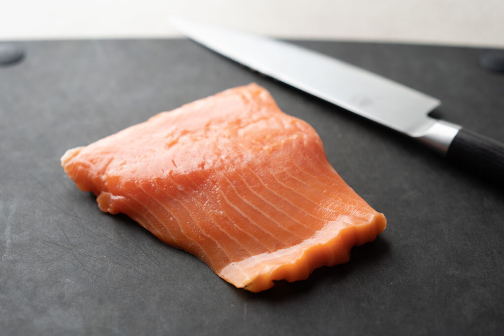 salmon fillet on black cutting board