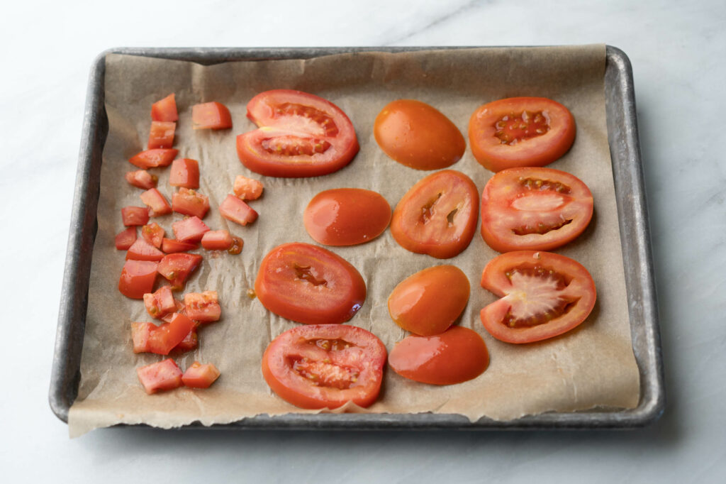 diced and sliced tomato on parchment paper